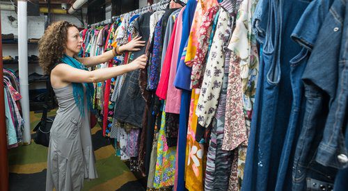 Woman browses vintage clothing for sale