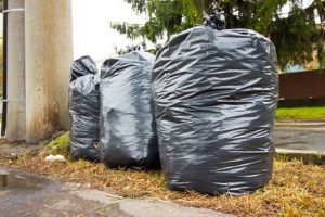 Trash bags of used clothing sitting out on the street