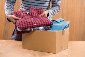 packing clothes into a box for donation