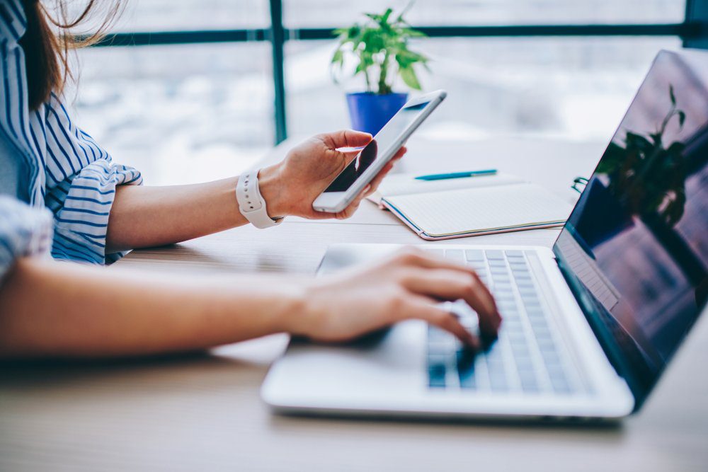 woman on phone with customer in front of laptop