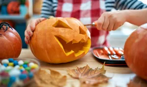 Woman carving a Halloween pumpkin