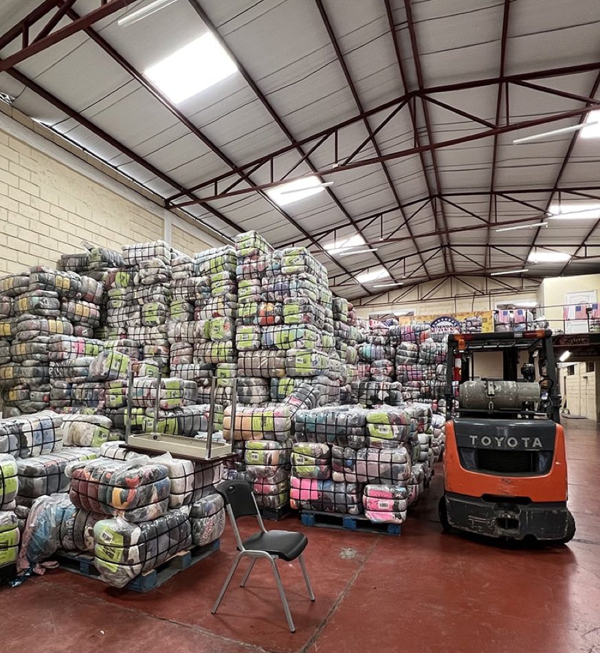 A warehouse with bales of clothing with machinery