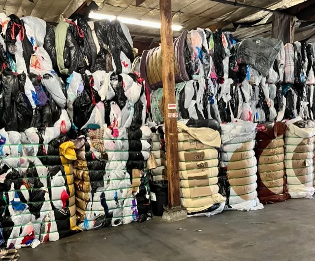 Stacks of used clothing in various different packages